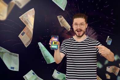 Your Bet Wins! Emotional man pointing at smartphone and money shower against dark background with fireworks