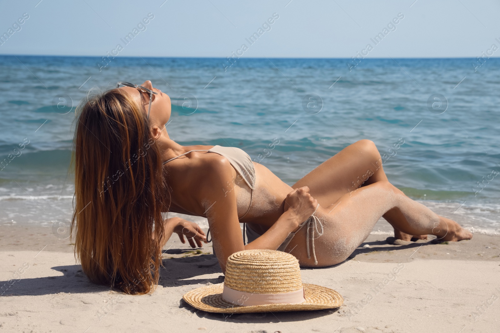 Photo of Attractive woman in bikini on sandy beach near sea