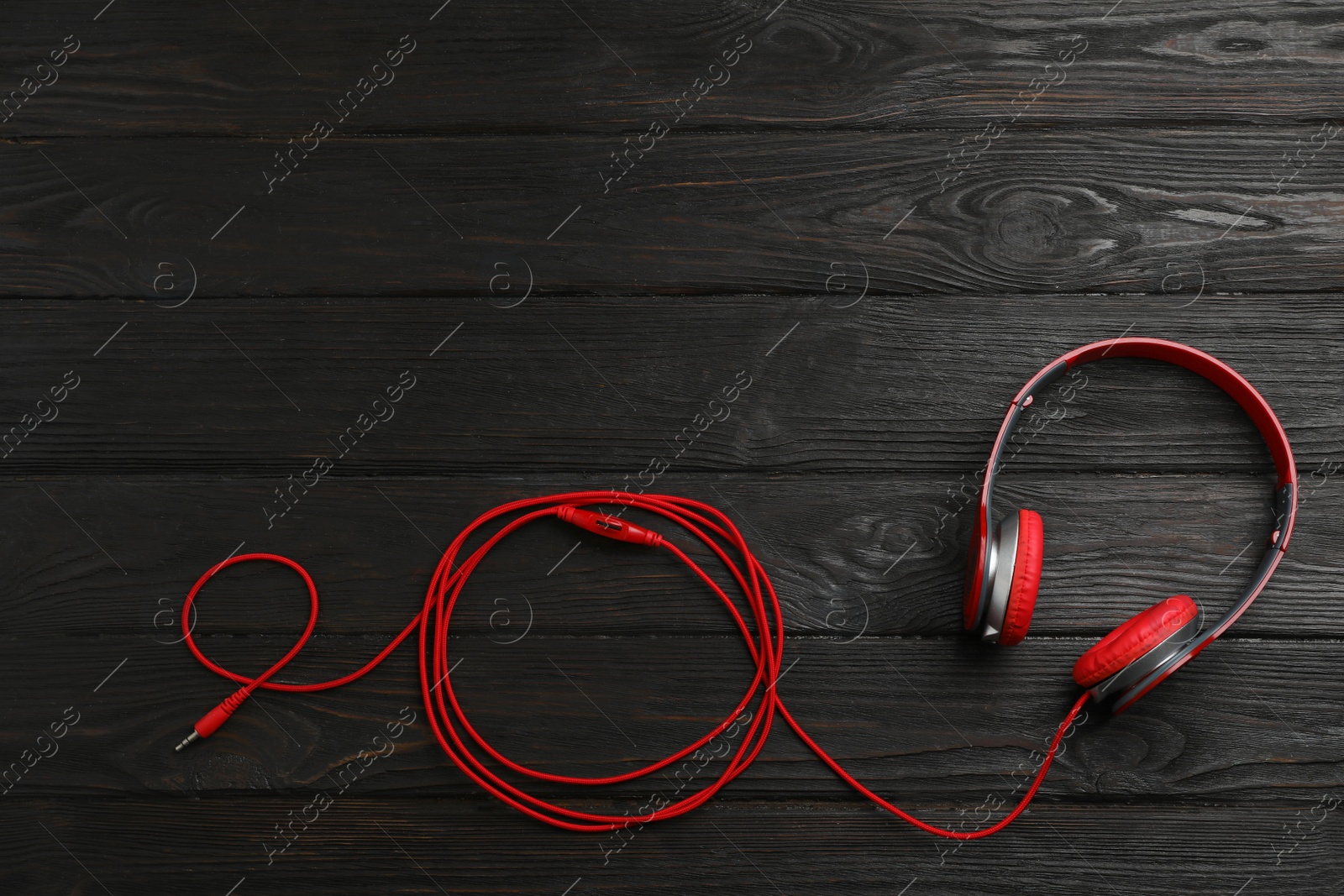 Photo of Stylish modern headphones and space for text on wooden background, top view