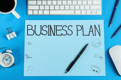 Photo of Flat lay composition of paper with words Business Plan on light blue background