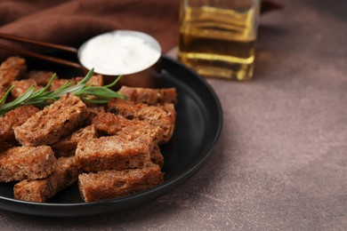 Photo of Crispy rusks with rosemary and sauce on grey table. Space for text