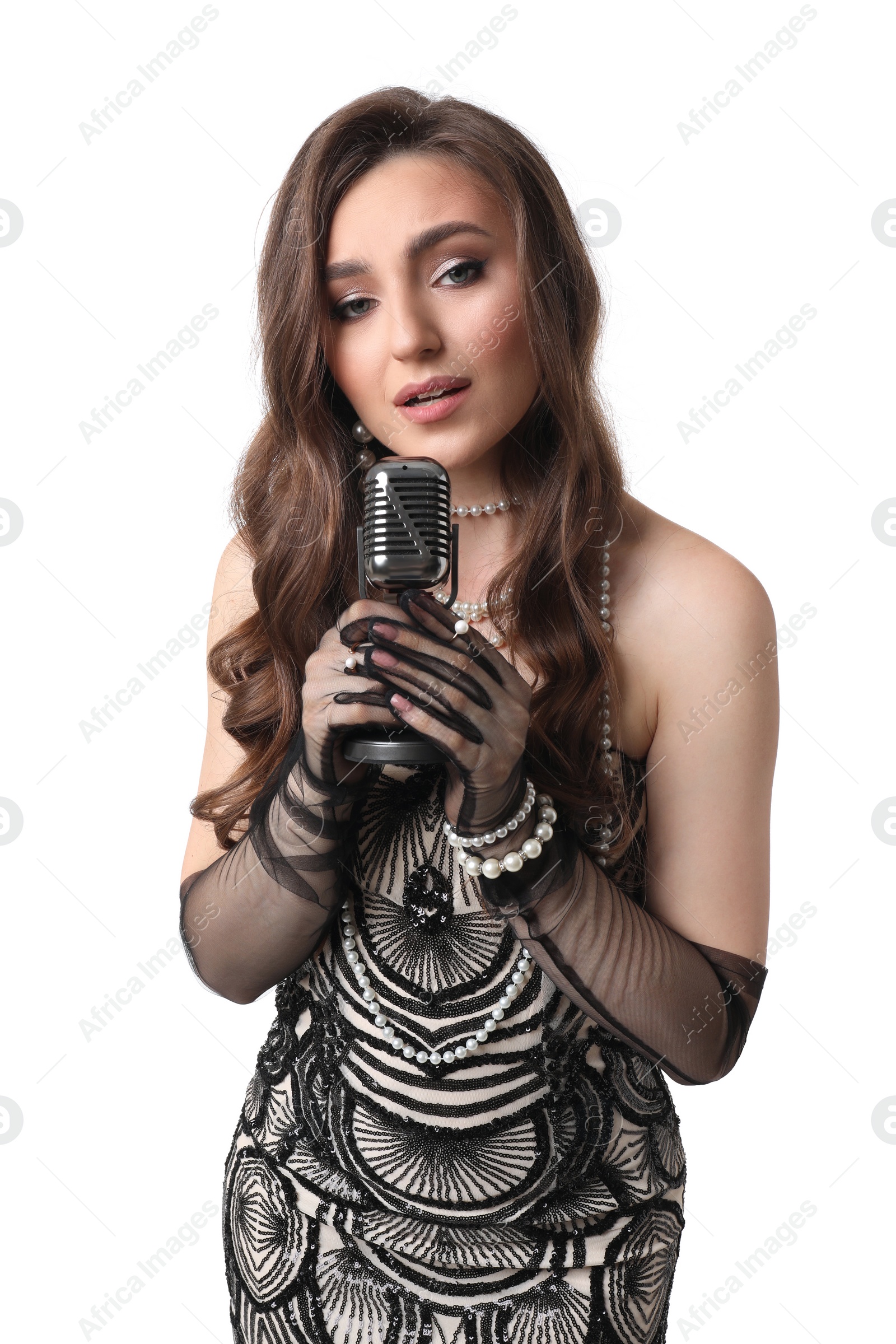 Photo of Beautiful young woman in stylish dress with microphone singing on white background