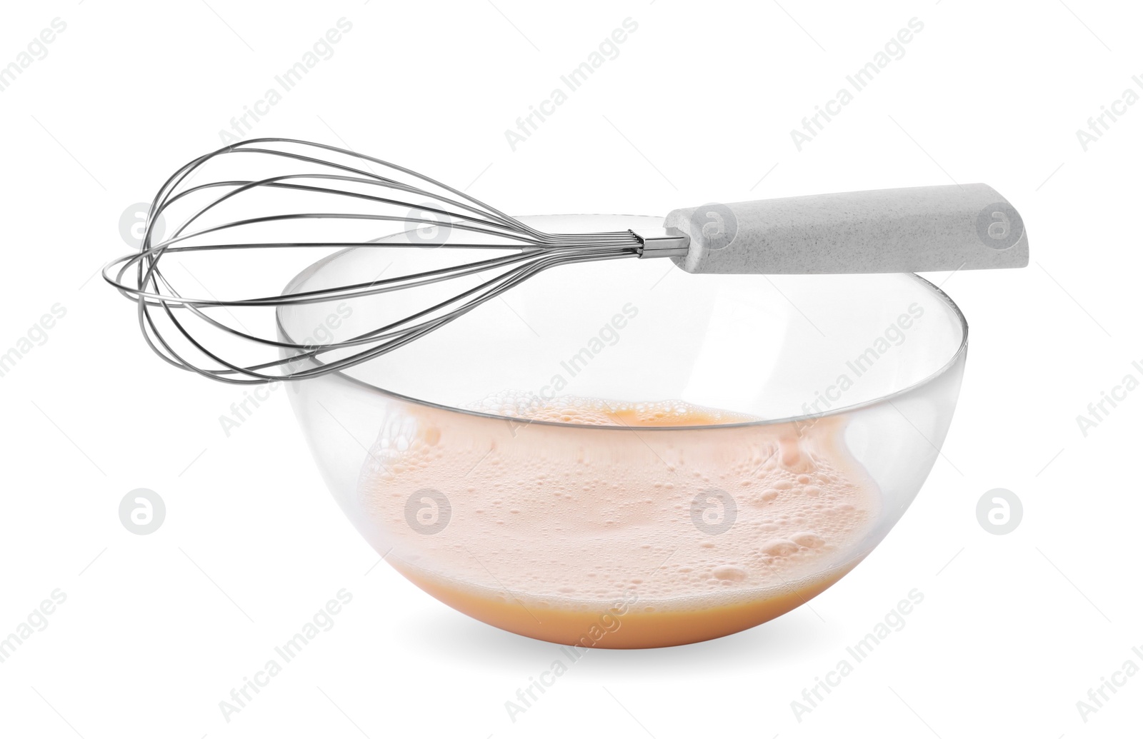 Photo of Beaten eggs in glass bowl and whisk isolated on white