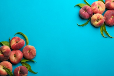 Photo of Fresh donut peaches on blue background, flat lay. Space for text
