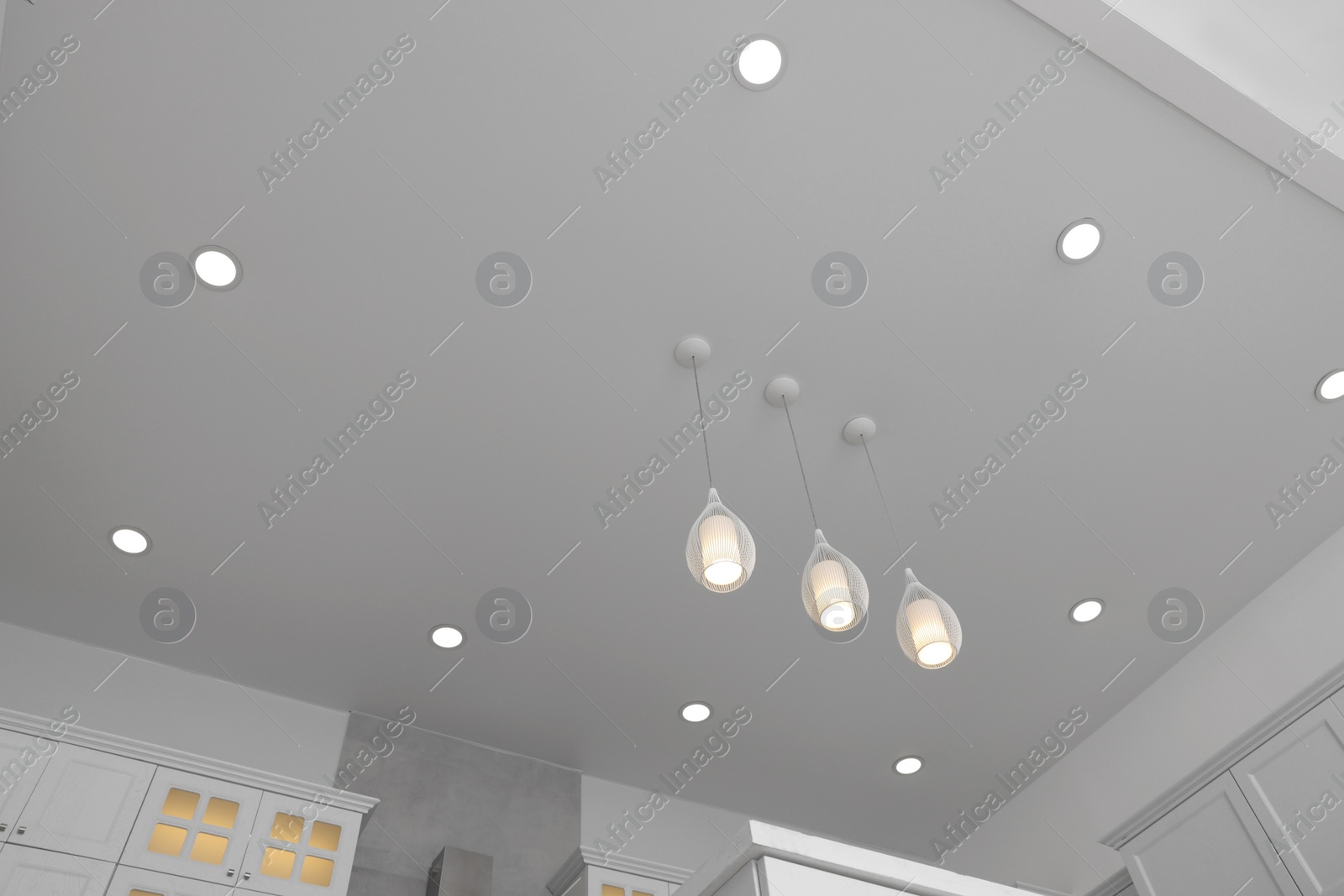 Photo of Ceiling with modern lamps and furniture in stylish kitchen, low angle view