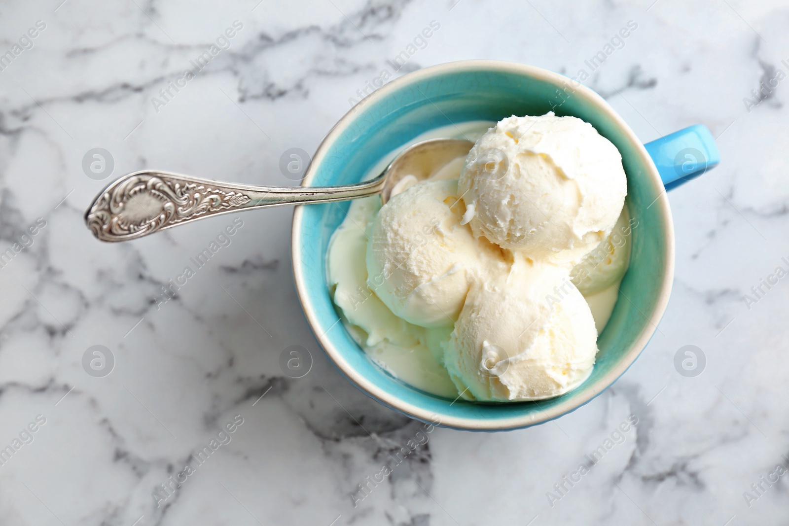 Photo of Cup with tasty vanilla ice cream on light background