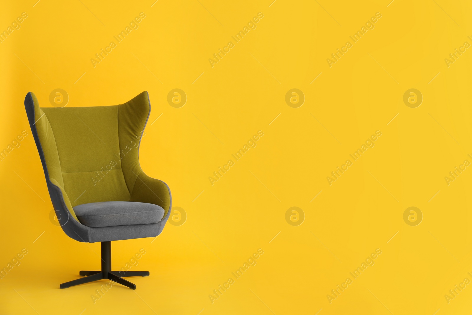 Photo of Modern office chair on yellow background. Space for text