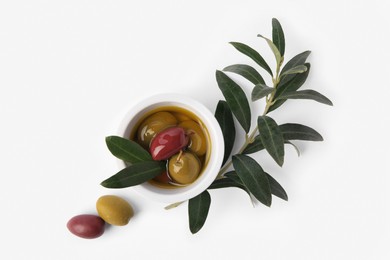 Photo of Bowl with different ripe olives and leaves on white background, flat lay