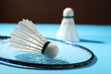 Feather badminton shuttlecocks and racket on court, selective focus