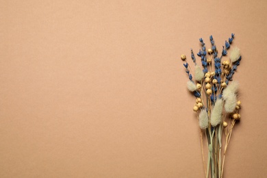 Photo of Bouquet of dried flowers on light brown background, flat lay. Space for text