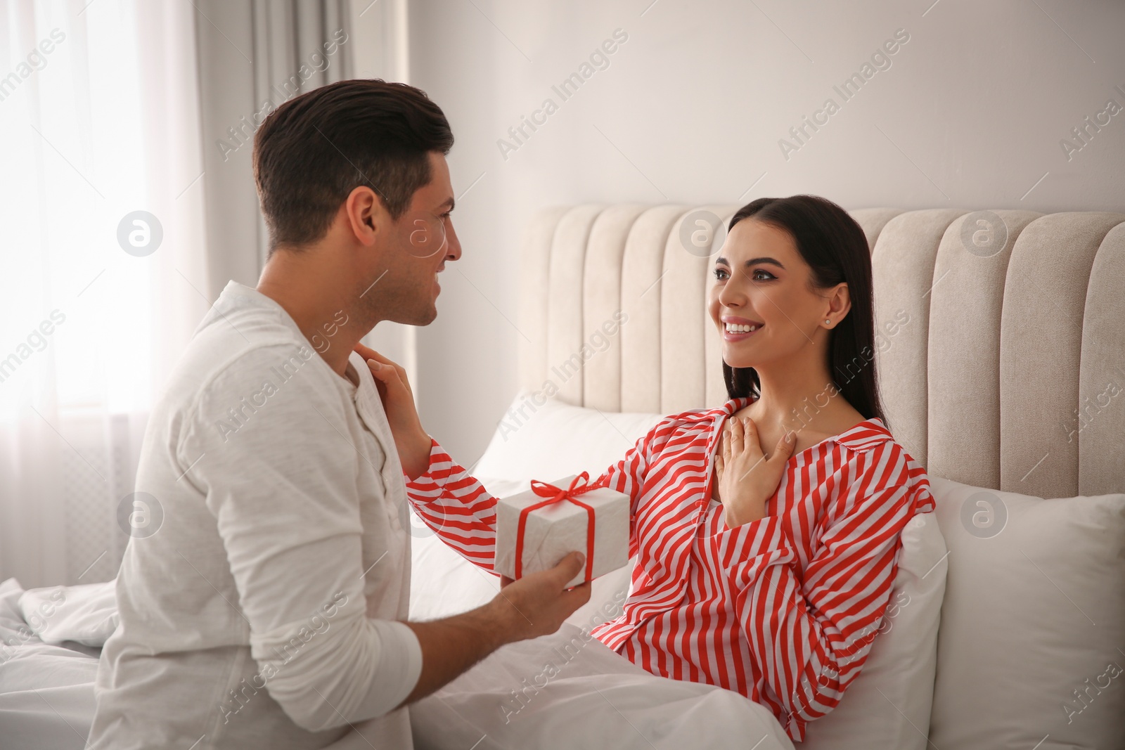 Photo of Lovely couple with gift box at home. Valentine's day celebration