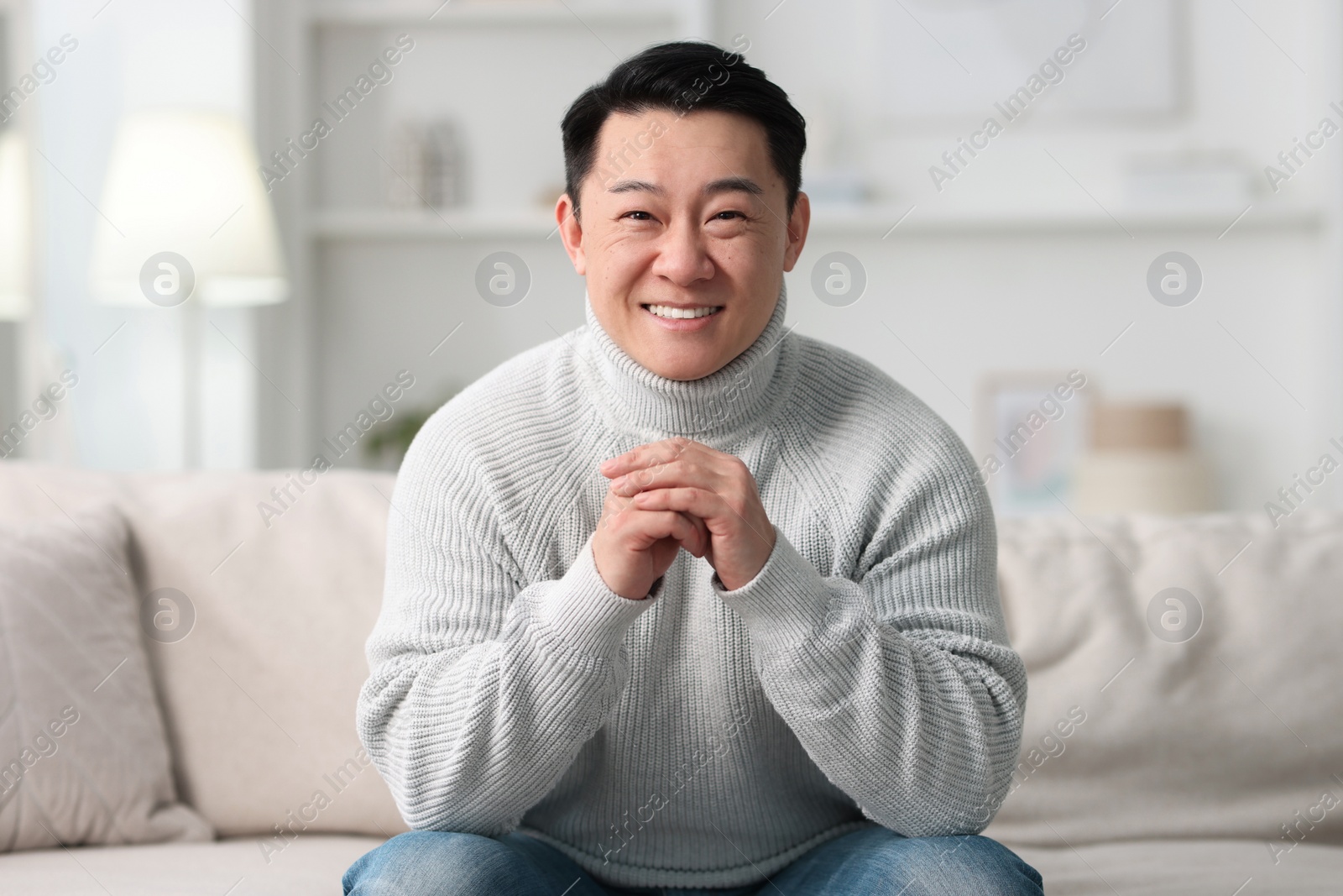 Photo of Portrait of smiling man on sofa indoors