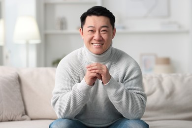 Photo of Portrait of smiling man on sofa indoors
