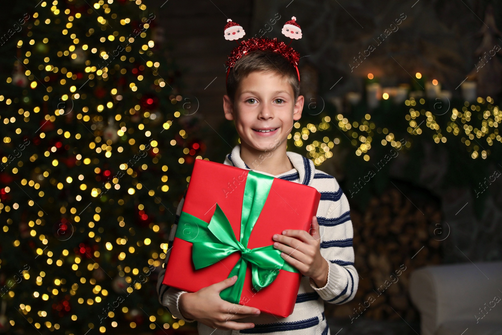 Photo of Portrait of happy child with Christmas gift at home