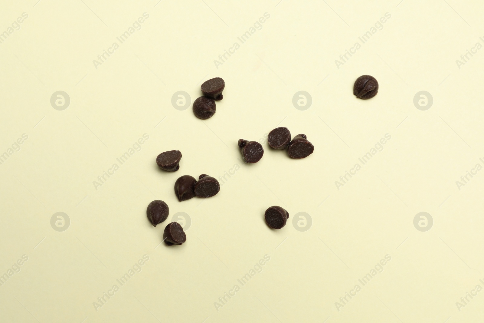 Photo of Delicious chocolate chips on beige background, top view