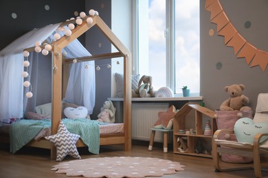 Stylish child room interior with house bed and different toys