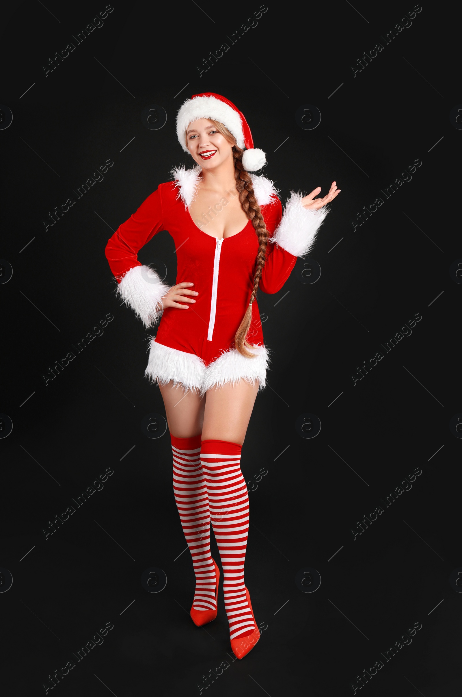 Photo of Beautiful Santa girl on black background. Christmas eve