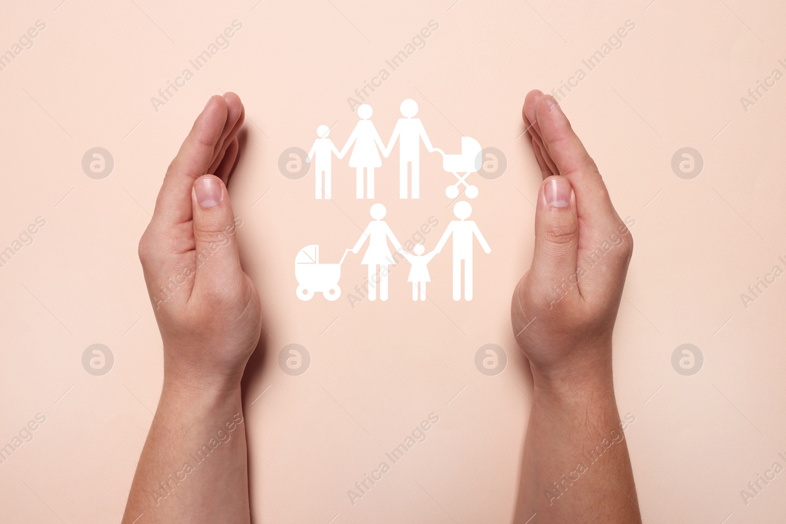 Image of Man holding hands around cutout paper silhouette of family on pink background, top view. Insurance concept