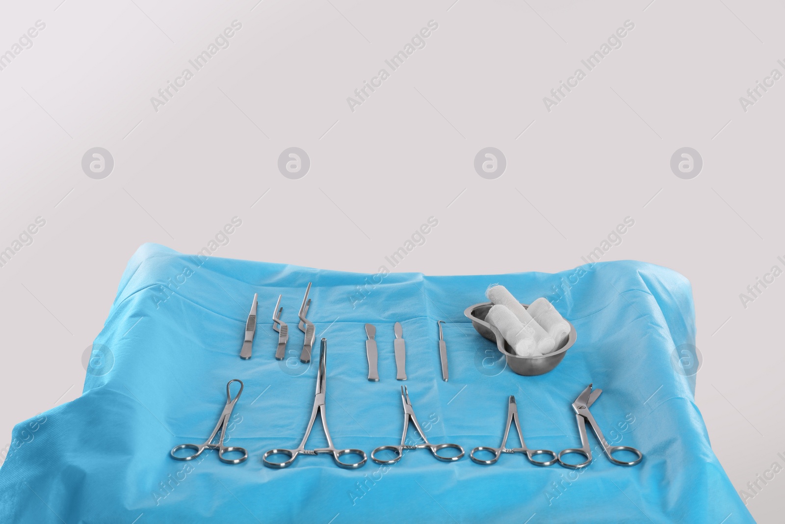 Photo of Different surgical instruments on table against light background