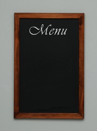 Image of Black chalkboard with word Menu on light grey background. Mockup for design