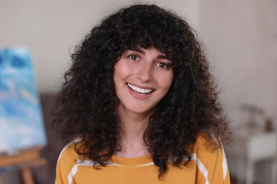 Portrait of happy young woman in stylish sweater indoors