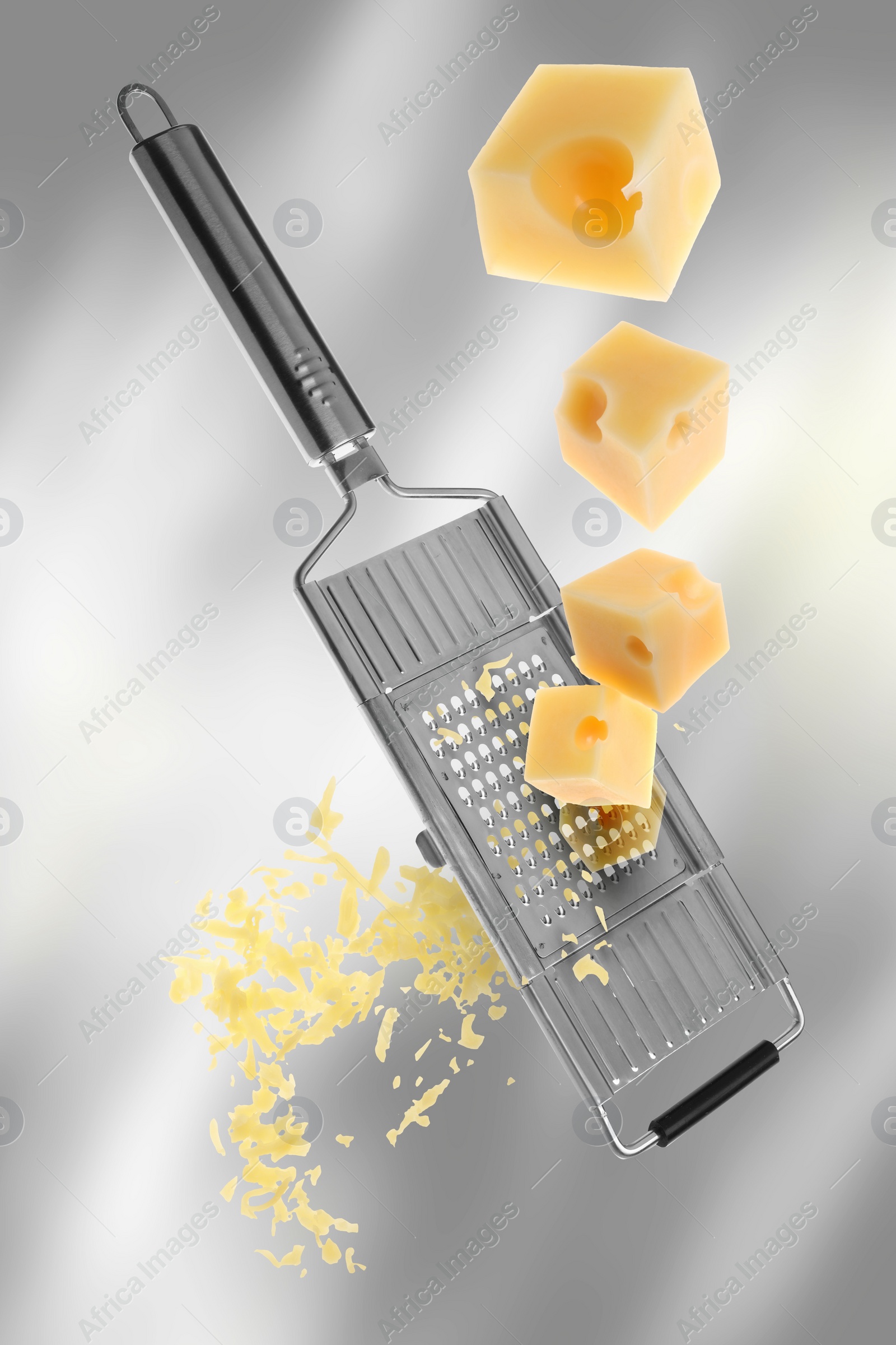 Image of Grating cheese with hand grater on grey gradient background