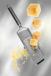 Image of Grating cheese with hand grater on grey gradient background