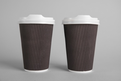 Carton cups on grey background. Mock up for design