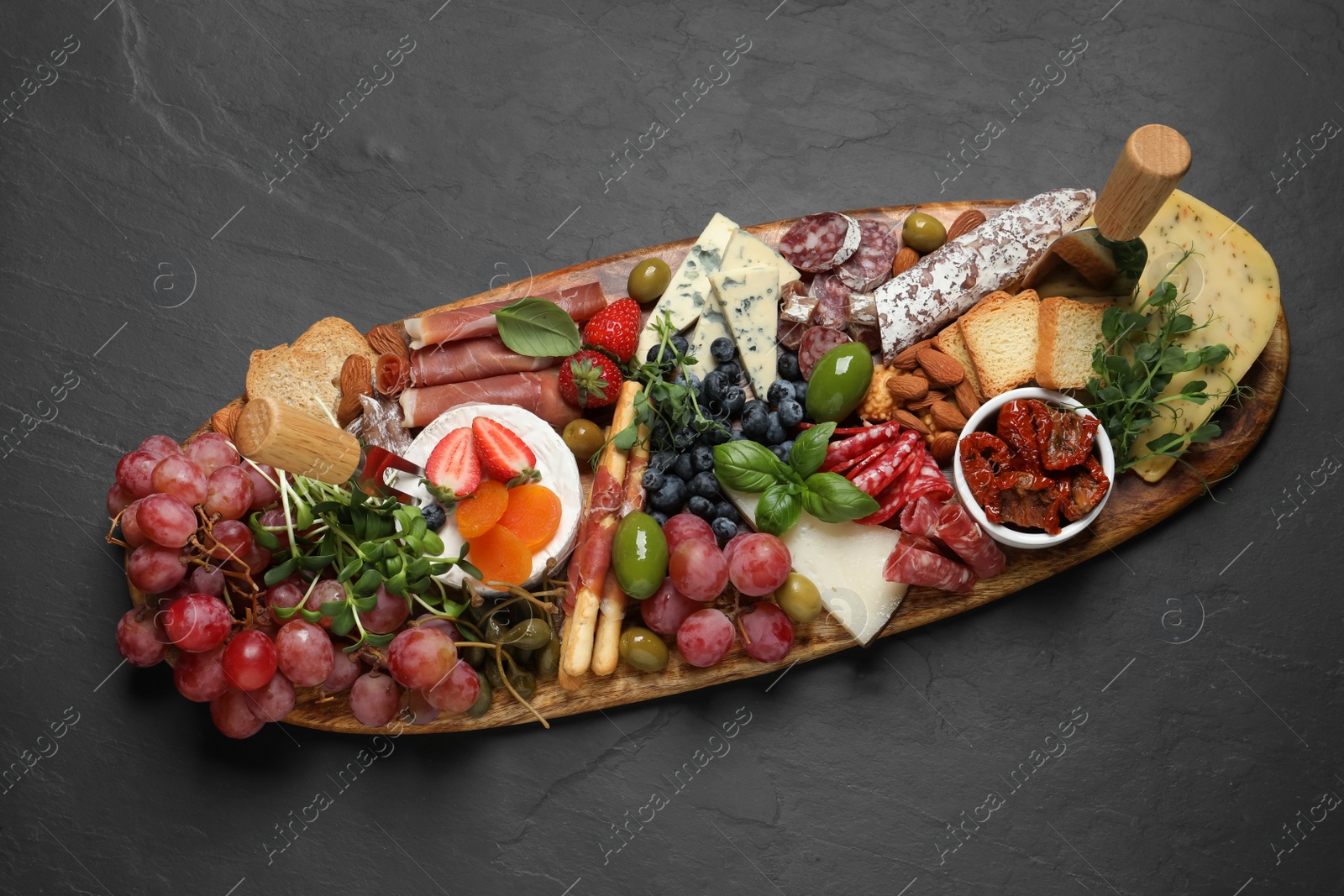 Photo of Set of different delicious appetizers served on black table, top view