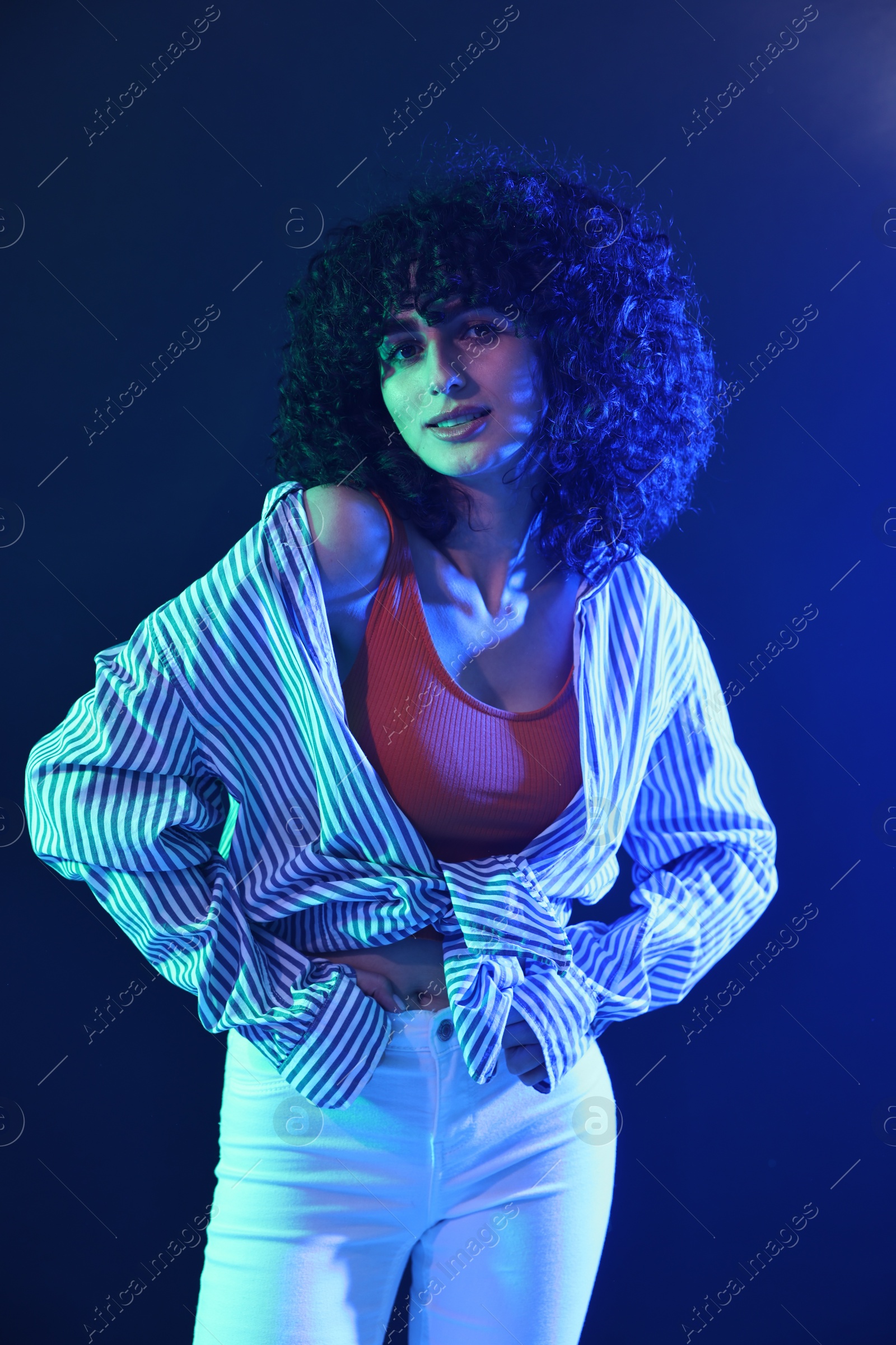 Photo of Beautiful young woman posing on color background in neon lights