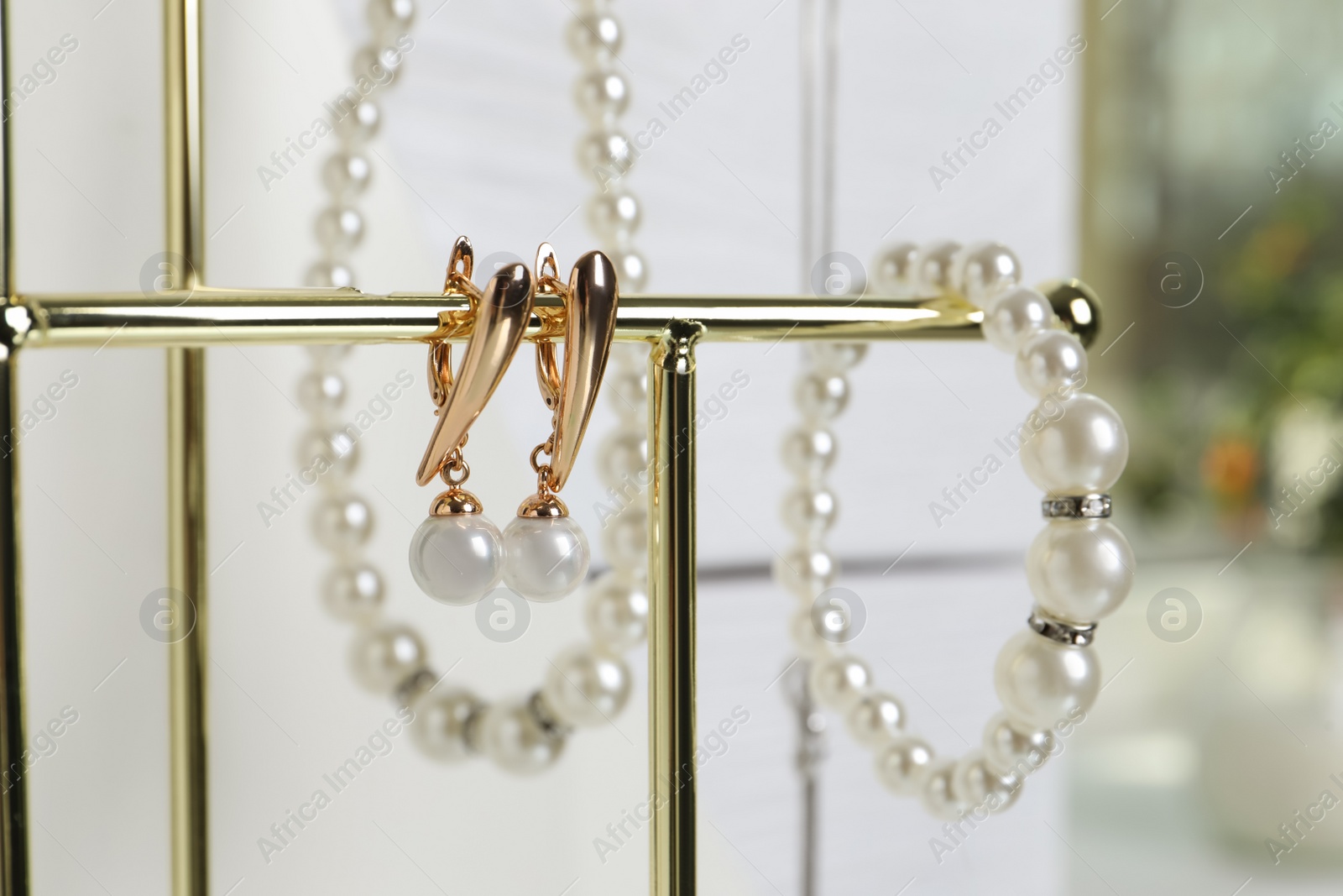 Photo of Luxurious pearl bracelet, earrings and necklace on stand, closeup view