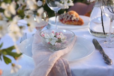 Stylish table setting with beautiful spring flowers in garden