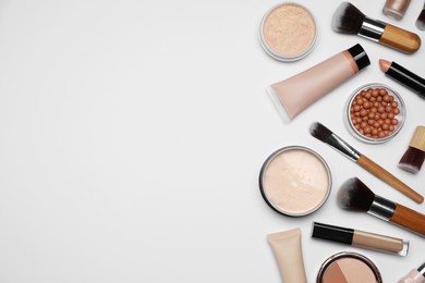 Photo of Face powders and other makeup products on white background, flat lay. Space for text