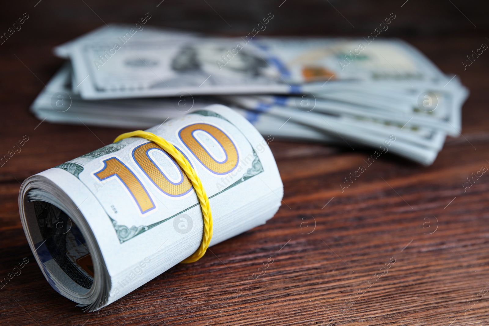 Photo of Many dollar banknotes on wooden table, closeup. Space for text