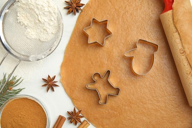 Photo of Flat lay composition with dough and cookie cutters on white table. Christmas biscuits