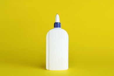 Photo of Blank bottle of glue on yellow background