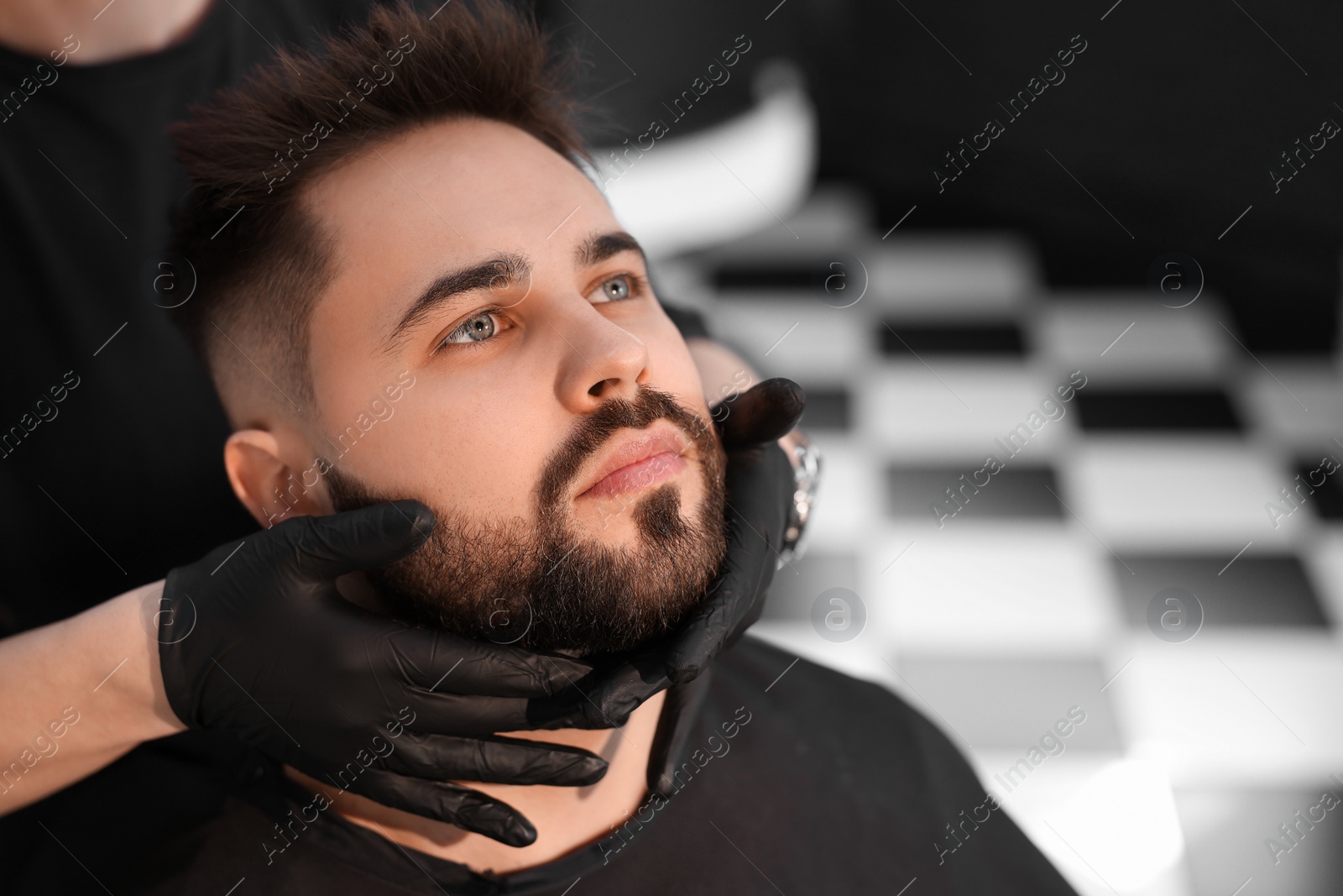 Photo of Professional hairdresser working with client in barbershop