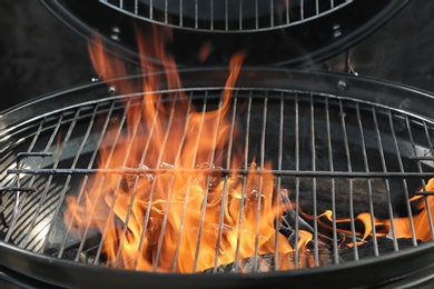 Photo of New modern barbecue grill with burning firewood, closeup