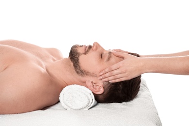 Handsome man receiving face massage on white background. Spa service