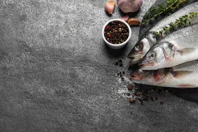 Tasty sea bass fish on grey textured table, flat lay. Space for text