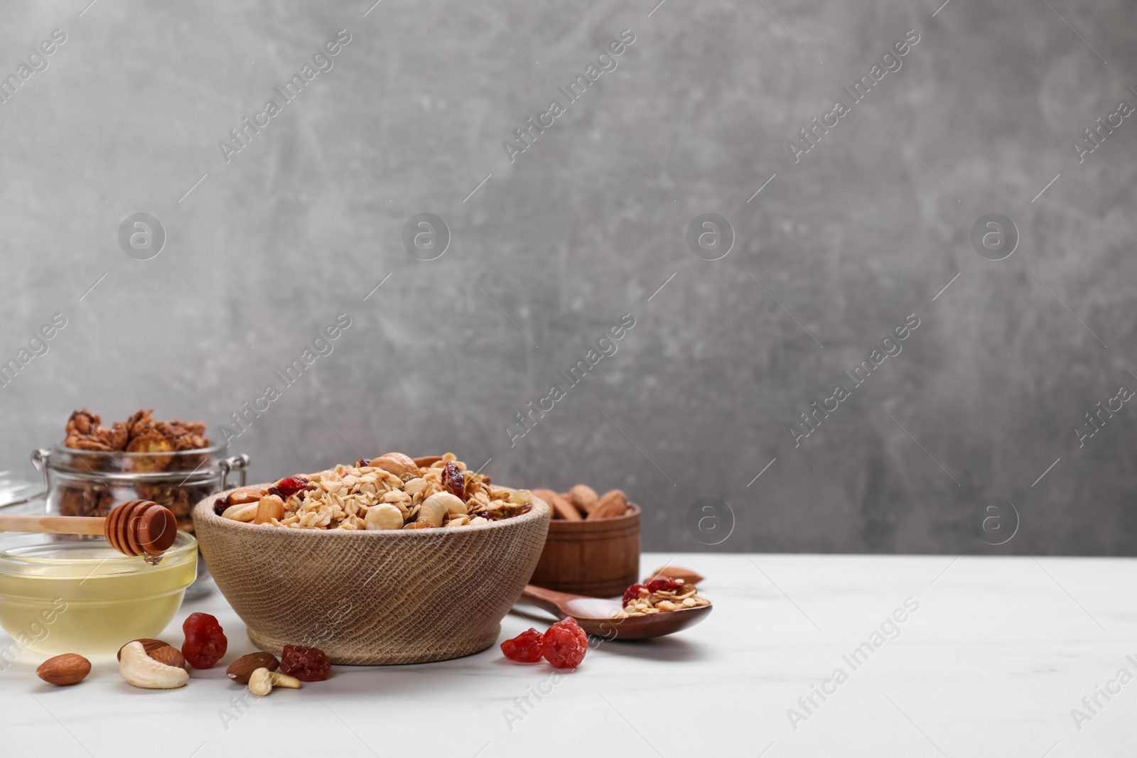 Photo of Tasty granola with nuts and dry fruits on white table. Space for text