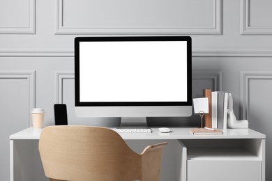 Cozy workspace with computer and stationery on white desk indoors. Interior design