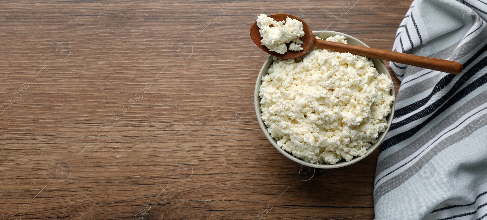 Photo of Delicious fresh cottage cheese on wooden table, top view. Space for text