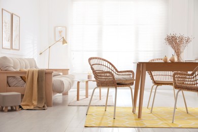 Dining room interior with wooden table and wicker chairs