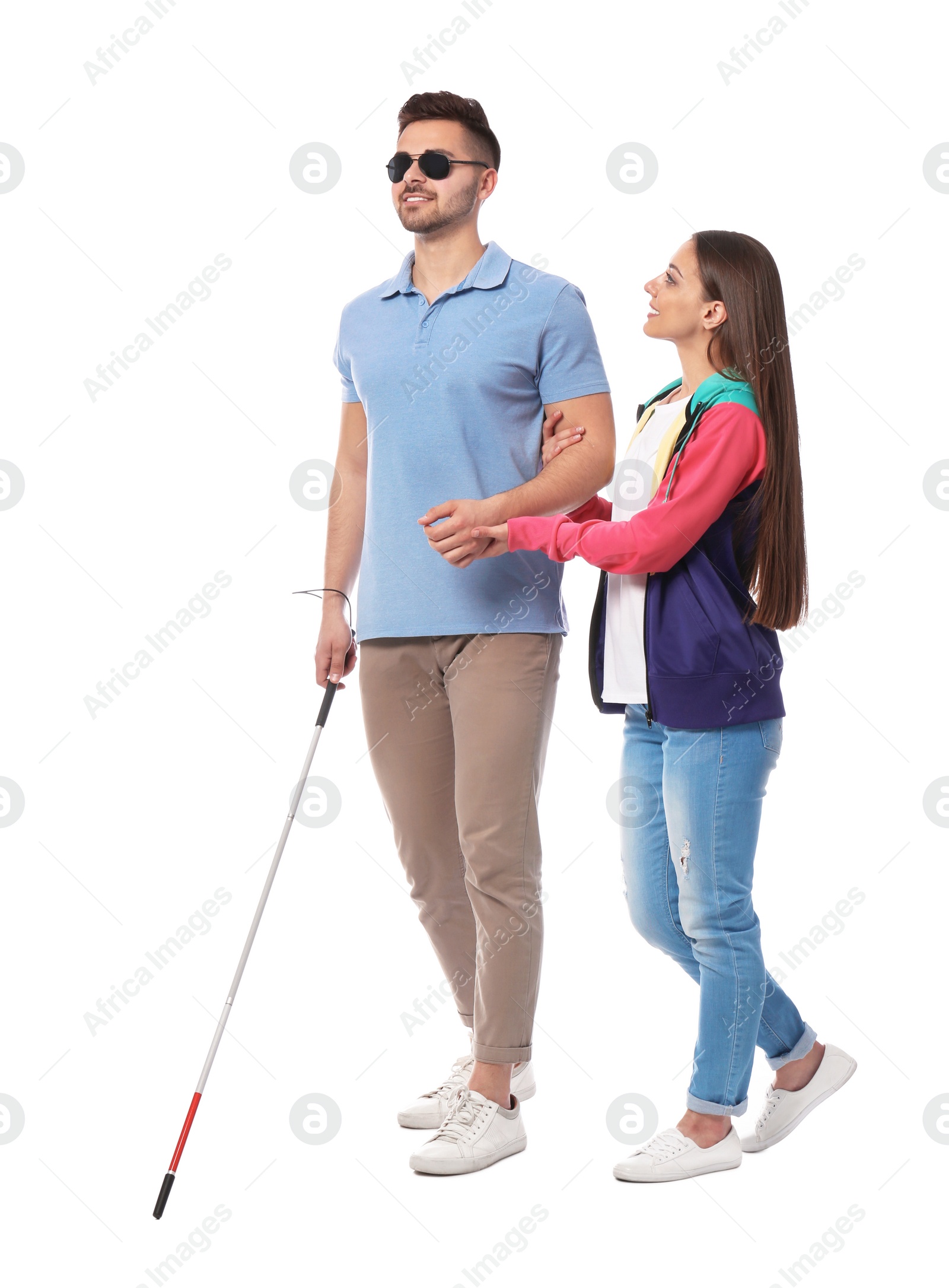 Photo of Young woman helping blind person with long cane on white background