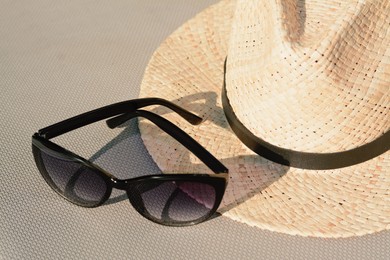 Photo of Stylish hat and sunglasses on grey surface