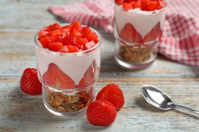Photo of Glasses with delicious yogurt and strawberries on old wooden table, closeup