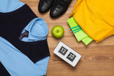 Photo of School uniform for boy and stationery on wooden background