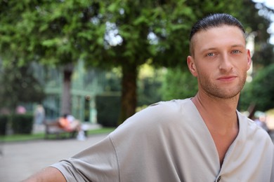 Photo of Portrait of handsome young man in park, space for text