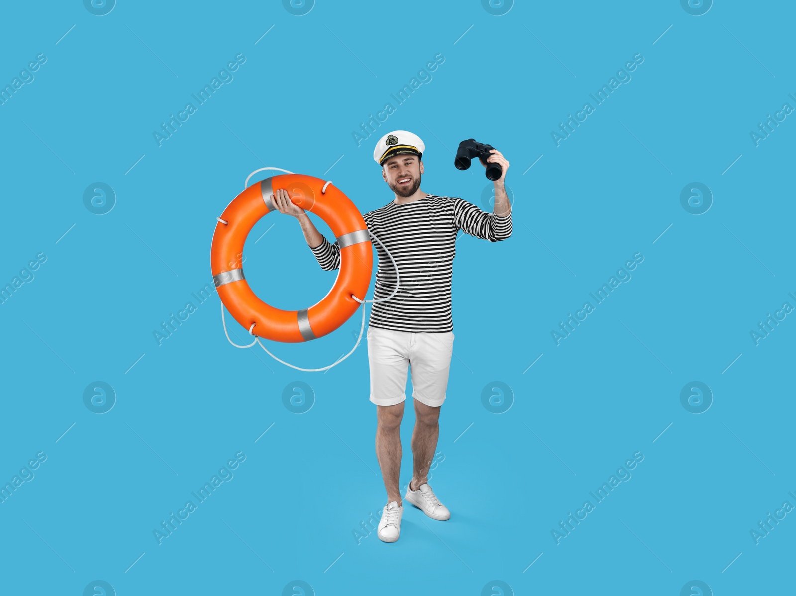 Photo of Sailor with binoculars and ring buoy on light blue background